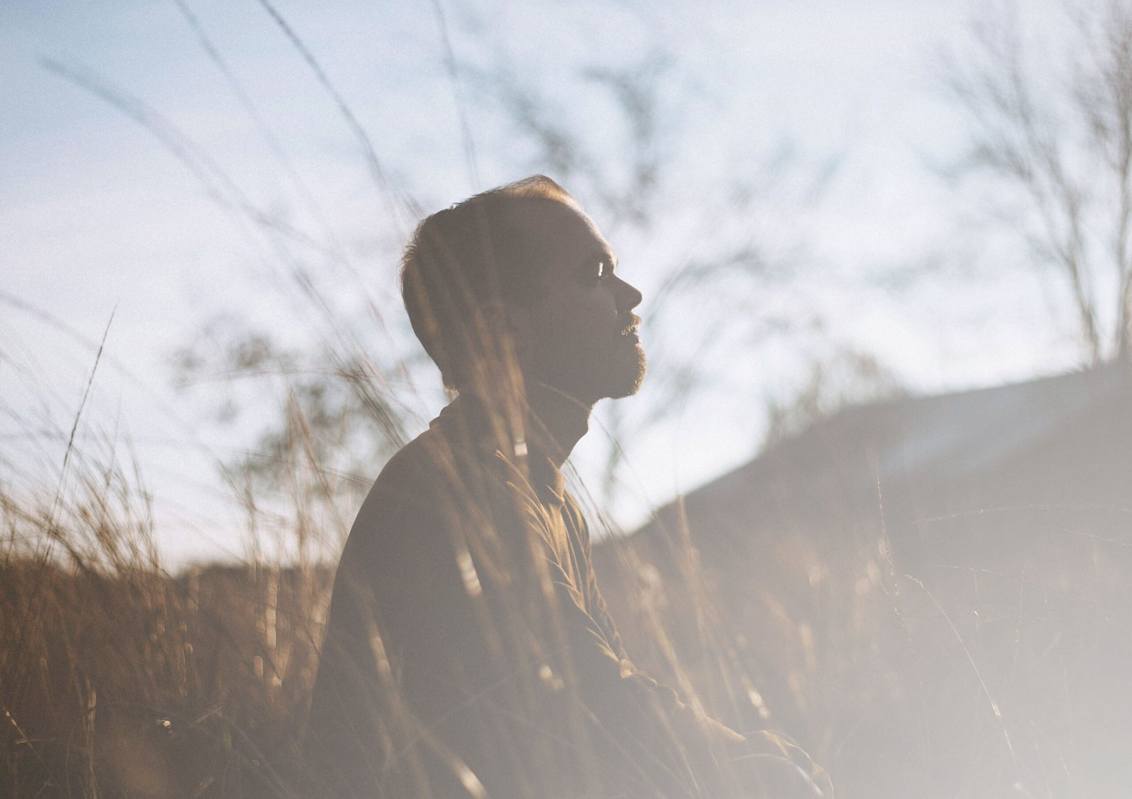 man meditating on a field